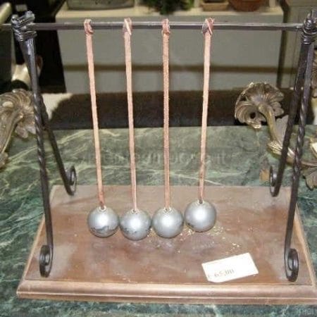 Vecchio gioco con sfere metalliche appese su struttura in metallo decorativa