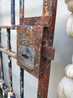 Vecchio cancello in ferro pieno, robusto e massiccio con cardini e grossa serratura