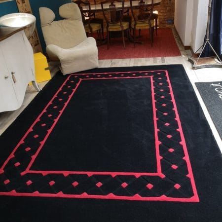 Tappeto moderno in lana scolpita nero con dettagli rossi marca Tisca