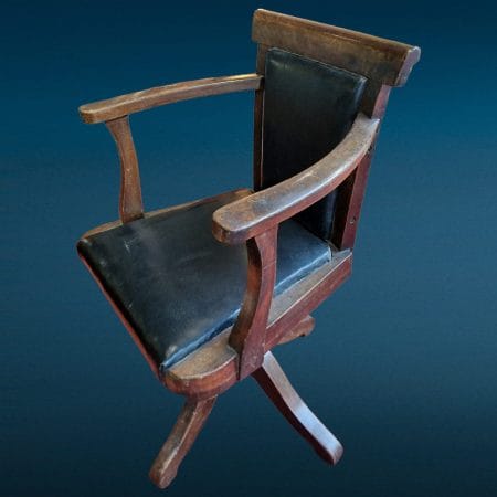 Vecchia poltroncina da ufficio anni '20 con base a quattro piedi e braccioli in legno