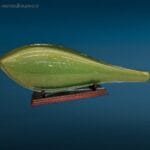 Scultura in vetro di Murano verde con scaglie d'oro raffigurante un elegante pesce su supporto in legno.